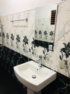 a white sink in a bathroom with black and white tiles at Green Horizon Ella in Ella