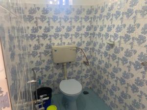 a bathroom with a toilet and a blue and white tiles at Secret Garden in Agonda