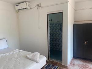 a bedroom with a bed and a glass shower at Secret Garden in Agonda