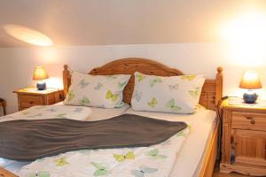 ein Bett mit zwei Kissen und einer Decke darauf in der Unterkunft Landhaus Müden in Faßberg