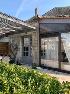 een uitbreiding van een huis met glazen schuifdeuren bij Maison des Roses in Saint-Savinien