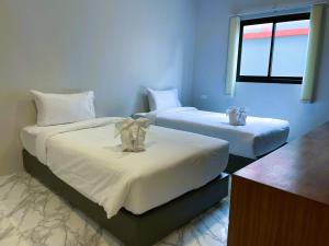 a bedroom with two beds with white sheets and a window at Terminal 58 in Ban Mut Dok Khao