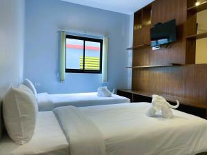 a hotel room with two beds and a window at Terminal 58 in Ban Mut Dok Khao