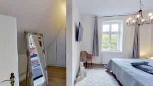 a bedroom with a bed and a window and a mirror at Ferienwohnung Leuchtturmwärter in Putgarten