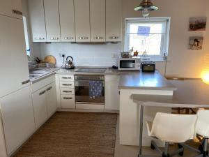 a kitchen with white cabinets and a table with chairs at Moonstone in Beadnell