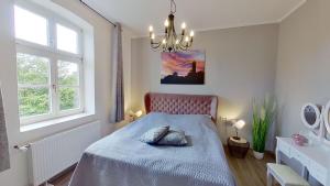 um quarto com uma cama e um lustre em Ferienwohnung Leuchtturmwärter em Putgarten