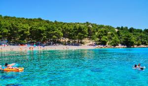 a group of people in the water at a beach at Grgo Apartments in Drage