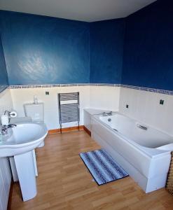 a bathroom with a tub and a sink and a toilet at Rosebank Lodge in High Bentham