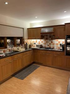 uma grande cozinha com armários e electrodomésticos de madeira em Rosebank Lodge em High Bentham