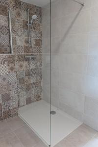 W łazience znajduje się prysznic ze szklanymi drzwiami. w obiekcie Villa Médicis Versailles Saint-Cyr-l'Ecole w mieście Saint-Cyr-lʼÉcole