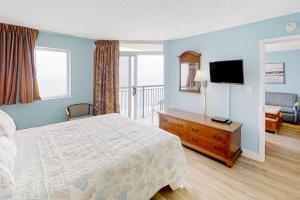 ein Hotelzimmer mit einem Bett und einem TV in der Unterkunft Roxanne Towers PH1 in Myrtle Beach