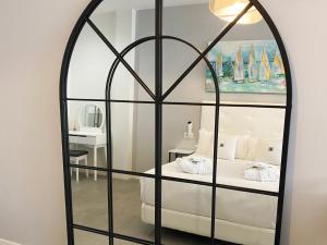 - un grand miroir dans une chambre avec un lit dans l'établissement The Old Town Boutique Hotel - Adults Only, à Estepona