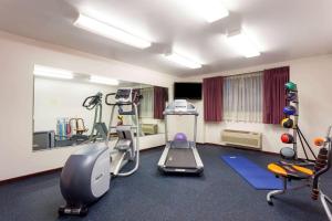 a room with a gym with a treadmill and weights at Days Inn by Wyndham Seatac Airport in SeaTac
