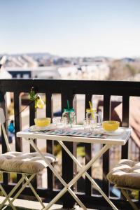 Biały stół na balkonie z okularami w obiekcie Appartement cosy avec vue imprenable sur Cabourg - accès direct plage - proche centre ville w mieście Cabourg +8 zdjęć