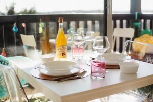 a table with two glasses and a bottle of wine at Appartement cosy avec vue imprenable sur Cabourg - accès direct plage - proche centre ville in Cabourg