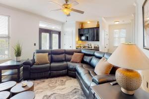 a living room with a leather couch and a table at Cassie's Beach Cottage in Destin