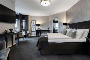 una camera d'albergo con un letto grande e una scrivania di Hotel Kronjylland a Randers