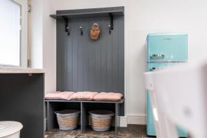 a bathroom with a blue door and baskets on a shelf at The Laurel Cottage in Doncaster