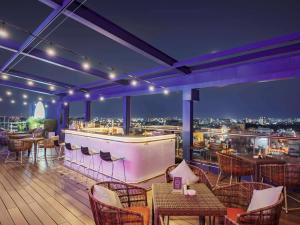 a restaurant with a bar with a view of the city at Ibis Saigon Airport in Ho Chi Minh City