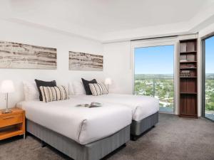 a bedroom with a large bed and a large window at The Sebel Maroochydore in Maroochydore