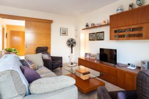 ein Wohnzimmer mit Sofa und Fernseher in der Unterkunft AT083 Bonita casa con piscina y barbacoa, zona muy tranquila in Creixell