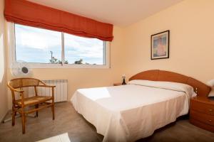 ein Schlafzimmer mit einem Bett und einem Stuhl und einem Fenster in der Unterkunft AT083 Bonita casa con piscina y barbacoa, zona muy tranquila in Creixell + 27 Fotos