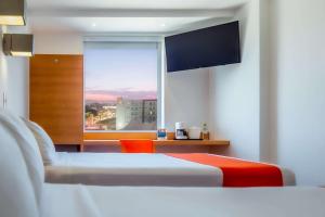 Habitación de hotel con 2 camas y ventana en Sleep Inn Leon Antares, en León