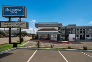 a building with a sign in front of a parking lot at Rodeway Inn South San Francisco Airport in South San Francisco