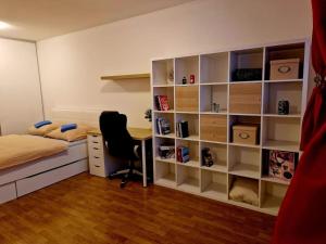 a bedroom with a bed and a desk and a book shelf at Slnečný byt v blízkosti historického centra in Trenčín