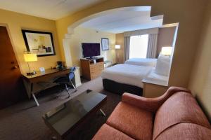 een hotelkamer met een bed en een bureau bij Wingate by Wyndham Greensboro-Coliseum in Greensboro