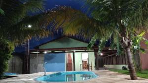 a pool in front of a house with a palm tree at Casa Vila Cintra in Pirenópolis