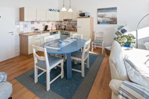 a kitchen and dining room with a blue table and chairs at Friesenbiene in Dornumersiel