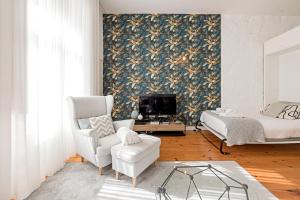 a living room with a couch a chair and a tv at LovelyStay - Cativo Studio Downtown by Metro Station in Porto