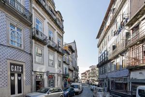 a city street with cars parked in front of buildings at LovelyStay - Cativo Studio Downtown by Metro Station in Porto