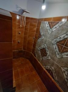 y baño con ducha de azulejos marrones. en Casa no Porto das Dunas Com Vista pro mar en Aquiraz