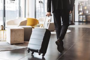 a man is pulling a suitcase in a room at the niu Belt in Eschborn