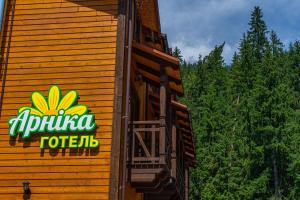 a restaurant sign on the side of a building at Arnika Hotel in Bukovel