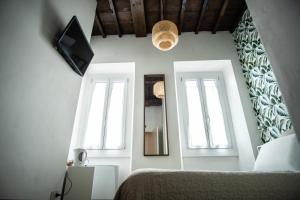 um quarto com 2 janelas, uma cama e uma televisão em Hotel Nella em Florença