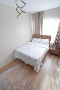 ein Schlafzimmer mit einem Bett mit weißen Laken und einem Kronleuchter in der Unterkunft Luxe Suite AI3 in Esenyurt