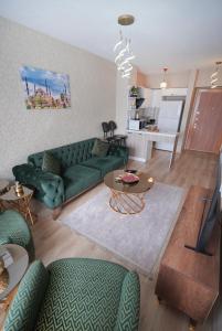 ein Wohnzimmer mit einer grünen Couch und einem Tisch in der Unterkunft Luxe Suite AI3 in Esenyurt