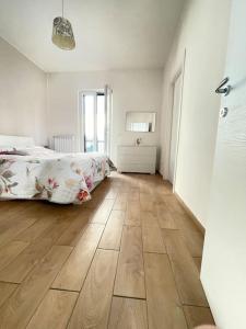 um quarto com uma cama e piso em madeira em Soluzione indipendente in centro em Frosinone