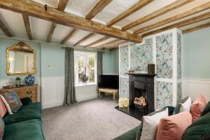 a living room with a fireplace and a green couch at The Laurel Cottage in Doncaster
