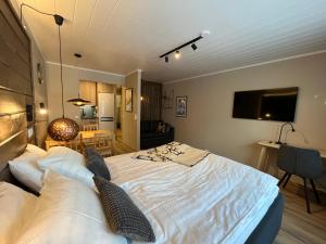 1 dormitorio con 1 cama grande y TV en la pared en Townhouse with SAUNA&FREE PARKING close to Santa Claus Village & Santa Park, en Rovaniemi