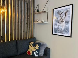 a living room with a couch and a picture of a deer at Townhouse with SAUNA&FREE PARKING close to Santa Claus Village & Santa Park in Rovaniemi