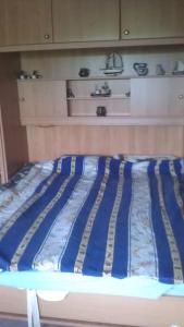 a bed with a blue and white comforter in a room at Nordsee und Natur. Gemütliche Fewo mit Deichblick in Dorum Neufeld