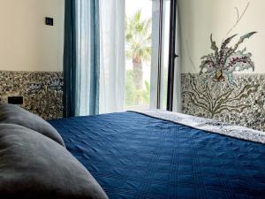a bedroom with a blue bed and a window at Mosaic villa by the sea in Protaras