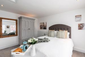 a bedroom with a white bed and a mirror at The Laurel Cottage in Doncaster