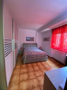 sypialnia z łóżkiem i dwoma czerwonymi oknami w obiekcie House Rose w mieście Rose