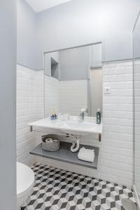 a white bathroom with a sink and a mirror at A Lodge in Blue in Aveiro
