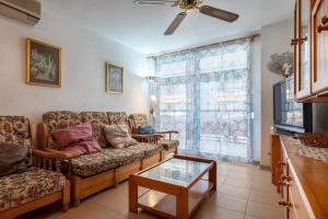 Una sala de estar con un sofá y una ventana. en AT046 Els Pins, 1ra línea de la playa, piscina, airco, aparcamiento, en Torredembarra